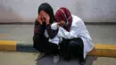 Perawat menangis atas kematian rekannya Razan al-Najjar di lorong rumah sakit Khan Yunis di Jalur Gaza selatan (1/6). Razan adalah sukarelawan Palestina berusia 21 tahun untuk kementerian kesehatan yang dikelola Hamas di Gaza. (AFP Photo/Kata Khatib)