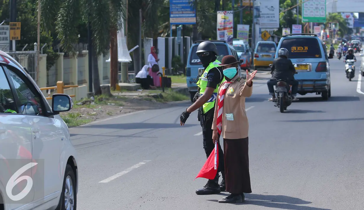 Anggota pramuka dan polisi mengatur lalu lintas jalur mudik di Cirebon, Jawa Barat, Jumat (1/7). Sebanyak 3.000-4.000 anggota pramuka Kwartir Daerah dikerahkan untuk membantu polisi memberikan pelayanan pada pemudik. (Liputan6.com/Angga Yuniar)