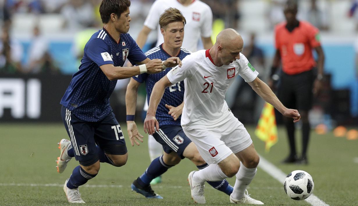 Pemain Polandia, Rafal Kurzawa berusaha melewati adangan para pemain Jepang pada laga terakhir grup H di Volgograd Arena, Volgograd, Rusia (28/6/2018). Jepang kalah 0-1 dari Polandia. (AP/Andrew Medichini)
