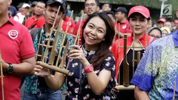 Warga memainkan angklung saat meramaikan acara 'Bangkit Indonesia' di Lokasi Car Free Day (CFD), Jakarta, Minggu (21/5). Acara memperingati Hari Kebangkitan Nasional itu dirayakan dengan pembagian 1.500 angklung. (Liputan6.com/Immanuel Antonius)
