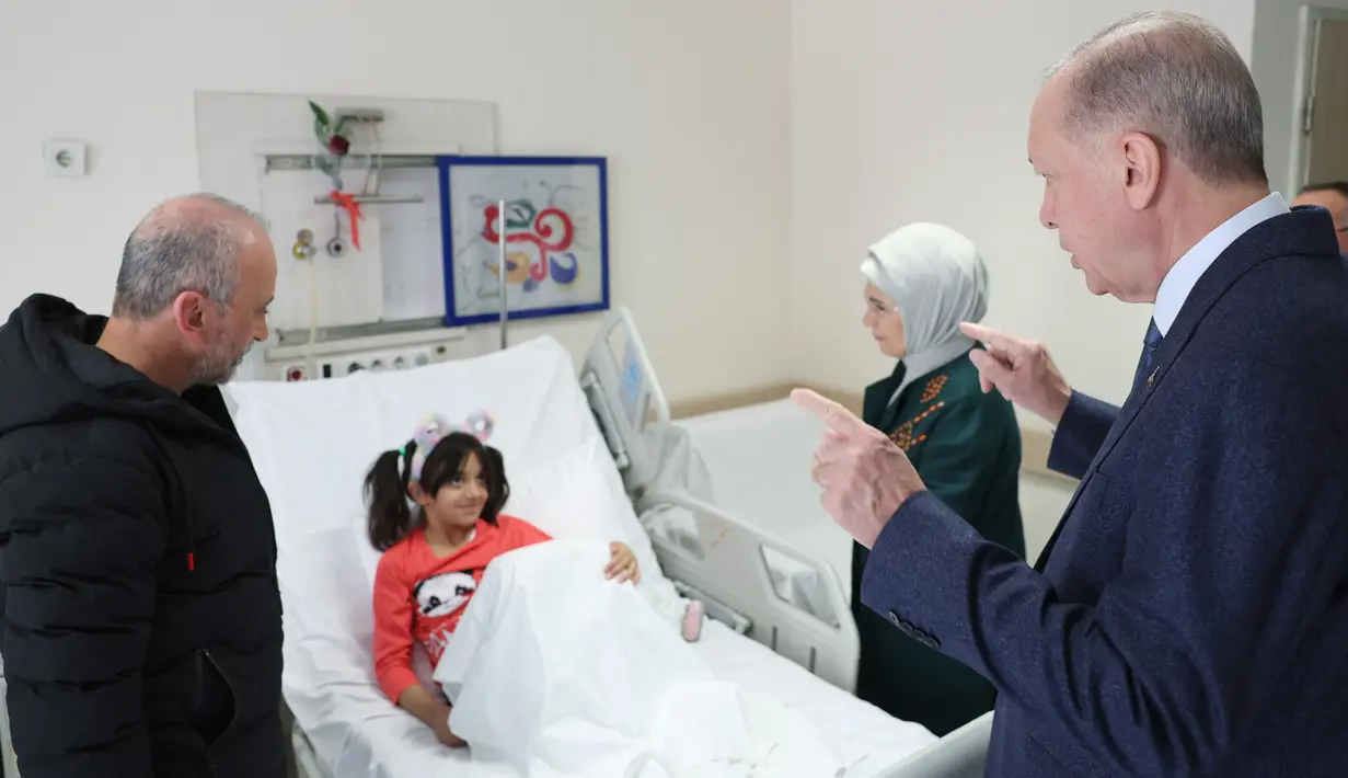 Presiden Turki Recep Tayyip Erdogan (kanan) dan istrinya Emine Erdogan mengunjungi anak korban gempa yang menerima perawatan di Fakultas Kedokteran Universitas Ankara setelah dipindahkan dari daerah yang dilanda gempa di Turki, 22 Februari 2023 .  Erdogan mengatakan total 70 ribu rumah akan dibangun di desa-desa terdampak gempa yang berpusat di Kahramanmaras, guna menghidupkan kembali daerah tersebut.  (Press Office of the Presidency of Turkey / AFP)