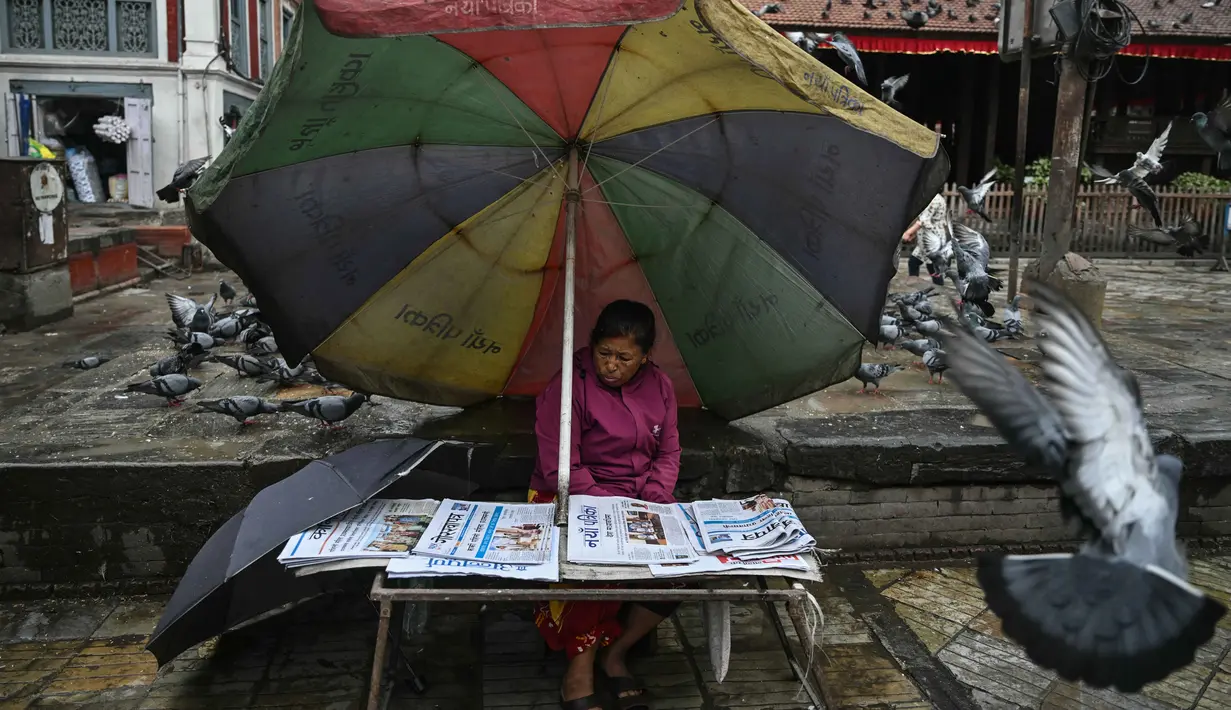 Seorang penjual koran terlihat duduk di tepi jalan di Durbar Square, Kathmandu, Nepal pada 13 September 2025. (Arun SANKAR/AFP)