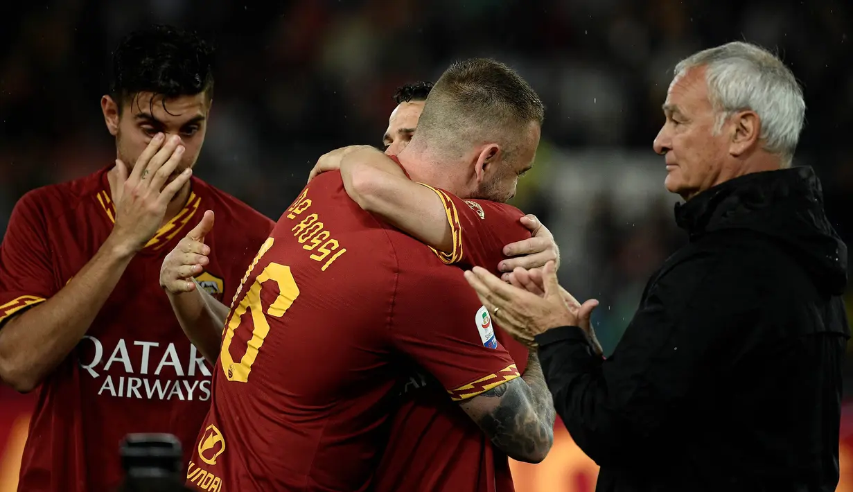 Gelandang AS Roma, Daniele De Rossi, memeluk rekannya usai melawan Parma pada laga Serie A di Stadion Olympic, Roma, Minggu (26/5). Laga ini perpisahan bagi De Rossi dan AS Roma setelah 18 tahun. (AFP/Filippo Monteforte)
