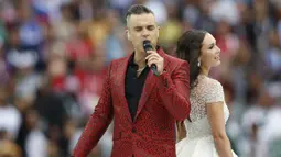 Penyanyi Rusia, Aida Garifullina, duet bersama penyanyi Inggris, Robbie Williams, saat pembukaan Piala Dunia di Stadion Luzhniki, Moskow, Kamis (14/6/2018). Laga pembuka Piala Dunia 2018 mempertemukan Rusia melawan Arab Saudi. (AP/Hassan Ammar)