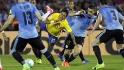 Striker Brazil, Neymar, berebut bola dengan pemain Uruguay. Neymar ikut memperbesar keunggulan dengan menciptakan gol tambahan pada menit ke-74. (AP/Matilde Campodonico)