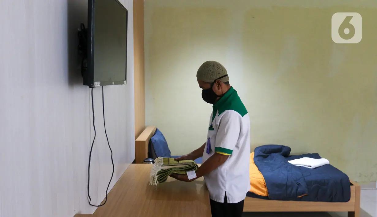 Petugas merapikan salah satu kamar tidur untuk calon jemaah haji di Asrama Haji Pondok Gede, Jakarta, Senin (23/5/2022). Asrama Haji Pondok Gede Jakarta siap melayani calon jemaah haji 1443 H/2022 M, yang dijadwalkan mulai masuk asrama pada 3 Juni 2022 mendatang sebelum keberangkatan menuju Tanah Suci Mekkah dan Madinah di Arab Saudi. (Liputan6.com/Herman Zakharia)