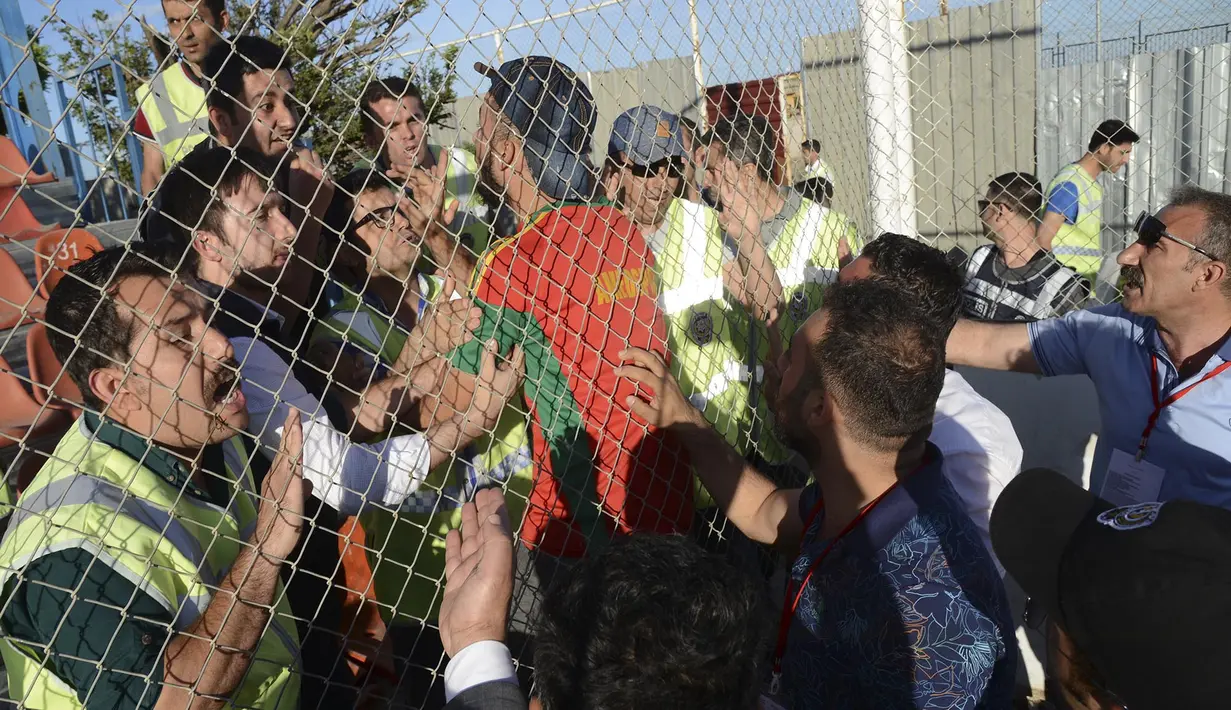 Pihak keamanan menenangkan fans klub Amedspor setelah timnya kalah dari Erzurum BB, Selasa (16/5/2017) di play-off untuk Liga Super Turki. (AFP/Ilyas Akengin)