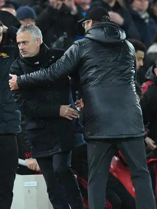 Manajer Manchester United, Jose Mourinho berjabat tangan dengan manajer Liverpool, Jurgen Klopp seusai pertandingan  lanjutan pekan ke-17 Premier League di Stadion Anfield, Minggu (16/12). MU tumbang di markas Liverpool dengan skor 1-3. (Paul ELLIS / AFP)