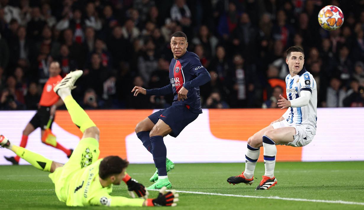 Pemain PSG, Kylian Mbappe (tengah) berusaha melepaskan tembakan meski ditepis oleh kiper Real Sociedad, Alex Remiro pada laga leg pertama 16 besar Liga Champions 2023/2024 di Parc des Princes, Paris, Prancis, Kamis (15/02/2024) WIB. (AFP/Franck Fife)