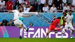 Pemain Iran Rouzbeh Cheshmi menendang bola untuk mencetak gol ke gawang Wales pada pertandingan sepak bola Grup B Piala Dunia 2022 di Stadion Ahmad Bin Ali, Al Rayyan, Qatar, Jumat (25/11/2022). Iran mengalahkan Wales dengan skor 2-0. (AP Photo/Frank Augstein)