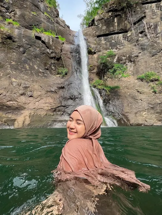 Pesona Alifhia Fitri saat bermain air di air terjun ini sangat menawan. Senyum tipisnya sambil memejamkan mata semakin membuat selebgram hits asal Bogor ini menyita perhatian. Foto Alifhia di alam bebas ini sukses bikin followersnya terpesona. (Liputan6.com/IG/@alifhiafitri)