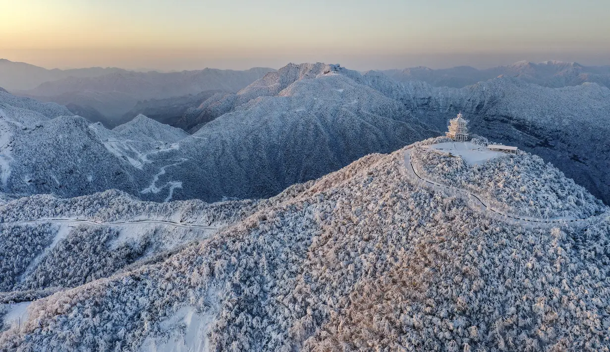 Pemandangan objek wisata Longtoushan saat matahari terbit di Distrik Nanzheng di Hanzhong, Provinsi Shaanxi, China barat laut yang terlihat dari foto udara pada 20 Desember 2020. Warna putih mendominasi pemandangan di musim dingin. (Xinhua/Tao Ming)