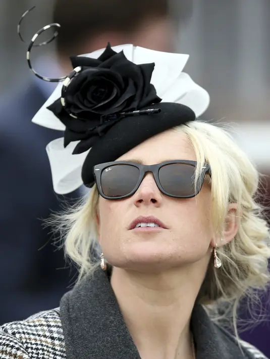 Seorang wanita menghadiri hari pertama Festival Cheltenham di Cheltenham Racecourse, Inggris, Selasa (15/3/2022). Festival empat hari berlangsung setiap tahun pada bulan Maret di Cheltenham Racecourse di Cheltenham, Gloucestershire. (Mike Egerton/PA via AP)