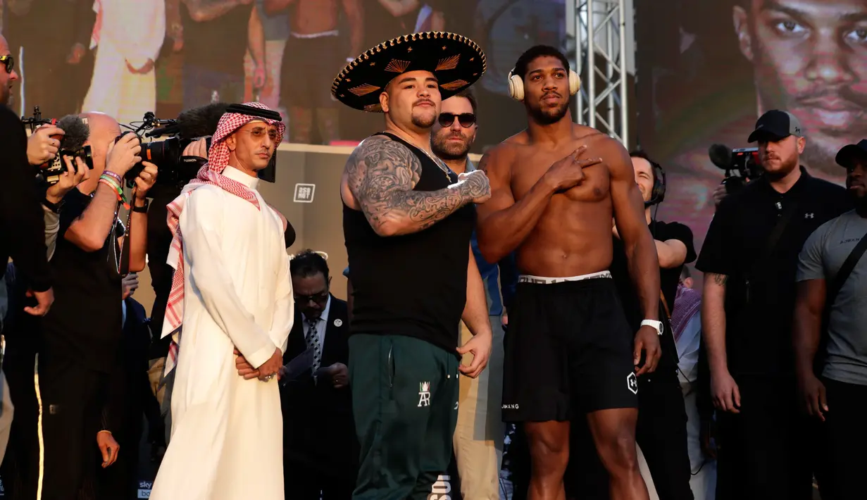 Petinju kelas berat Anthony Joshua (kanan) dan Andy Ruiz Jr (kiri) berpose saat timbang badan resmi di Riyadh, Arab Saudi, Jumat (6/12/2019). Anthony Joshua akan menghadapi Andy Ruiz Jr pada 7 Desember 2019. (AP Photo/Hassan Ammar)