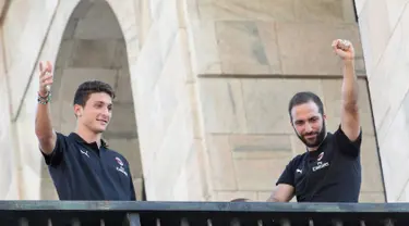 Pemain baru AC Milan, Gonzalo Higuain (kanan) dan Mattia Caldara menyapa suporter dari balkon di alun-alun pusat Milan Piazza Duomo (3/8). Higuain dan Caldara didapatkan Milan dari Juventus. (AFP Photo)