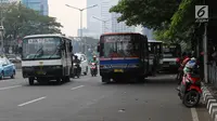 Bus Kopaja dan Metromini melintas di Jalan Jenderal Sudirman, Jakarta, Rabu (4/7). Wagub DKI Jakarta Sandiaga Uno melarang angkutan umum seperti Kopaja dan Metromini melintasi jalan protokol selama Asian Games 2018. (Liputan6.com/Arya Manggala)