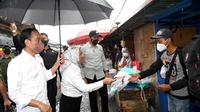 Presiden Joko Widodo dan Ibu Negara Iriana memberikan bantuan di Pasar Kertek, Kabupaten Wonosobo, Provinsi Jawa Tengah, Selasa (14/12/2021). (Biro Pers Sekretariat Presiden)