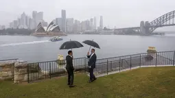 Pertemuan Jokowi dengan Anthony Albanese berlangsung akrab. Di bawah rintik hujan, keduanya menyaksikan Sydney Opera House dari kejauhan. (Lisa Maree Williams/Pool via AP)