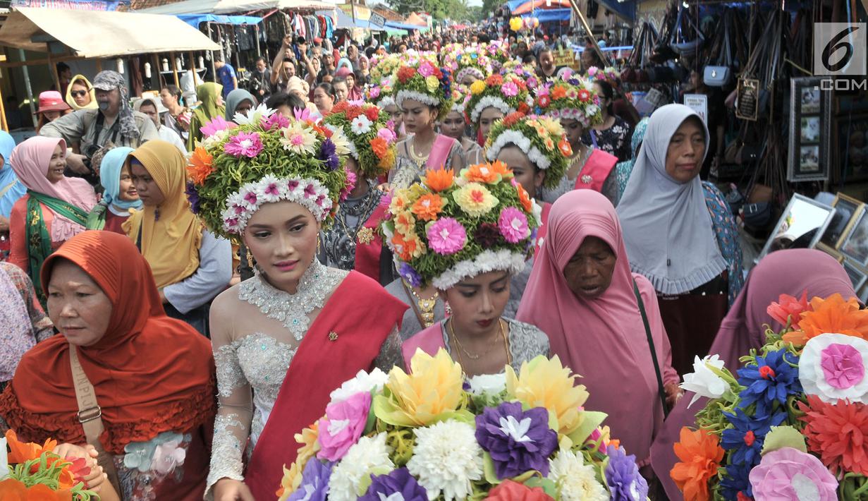 Arak-arakan puluhan gadis saat mengikuti upacara adat Ngarot di Desa Lelea, Indramayu, Jawa Barat, Rabu (19/12). Ngarot dimulai dengan arak-arakan para gadis yang dimeriahkan oleh lantunan musik tradisional menuju Balai Desa. (Merdeka.com/Iqbal Nugroho)
