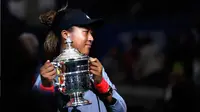 Petenis Jepang, Naomi Osaka memegang trofi turnamen AS Terbuka setelah mengalahkan petenis AS, Serena Williams pada partai final di Arthur Ashe Stadium, New York, Sabtu (8/9). Naomi Osaka menang dua set dengan skor 6-2 dan 6-4. (AP/Adam Hunger)