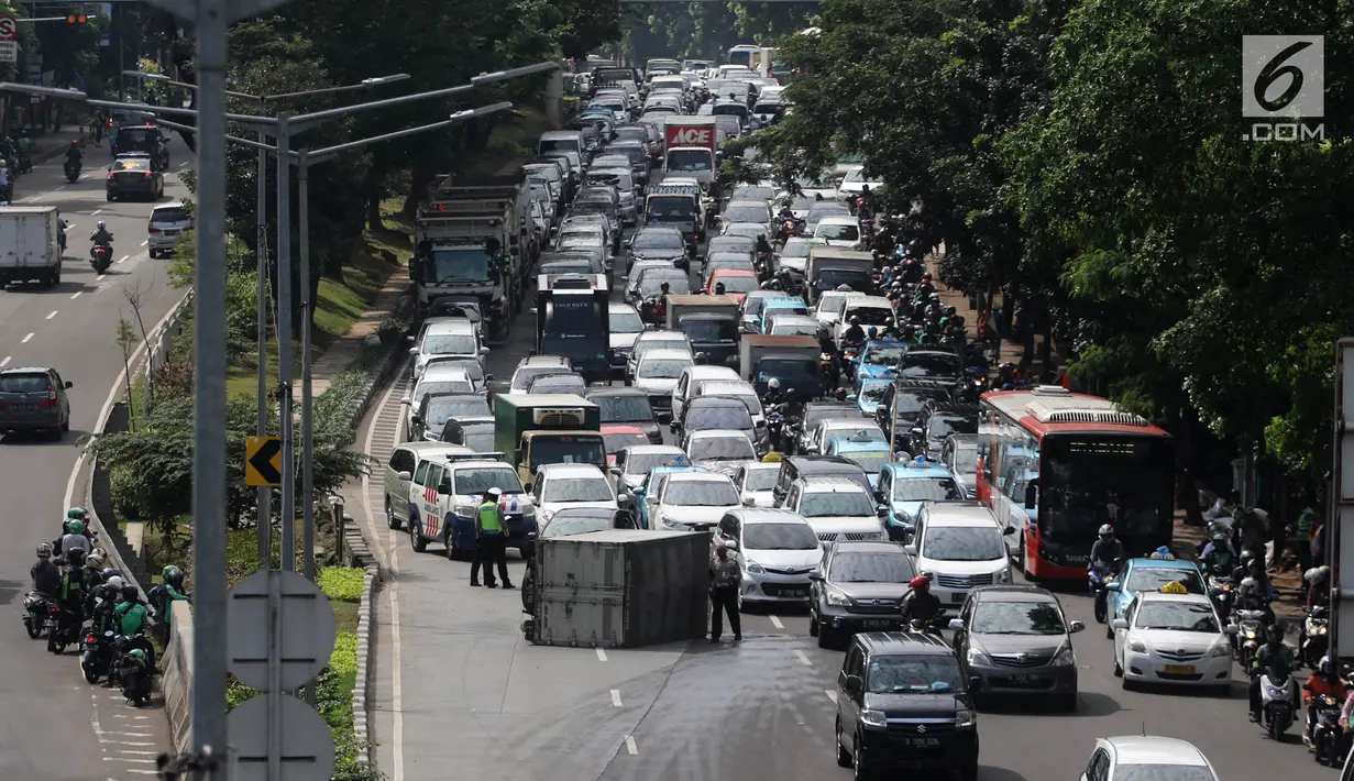 Sebuah mobil boks terguling di Jalan Casablanca, Jakarta, Rabu (27/6). Akibat kejadian tersebut, arus lalu lintas di sekitar Mal Kota Casablanka cukup padat dan tersendat. (Liputan6.com/Arya Manggala)