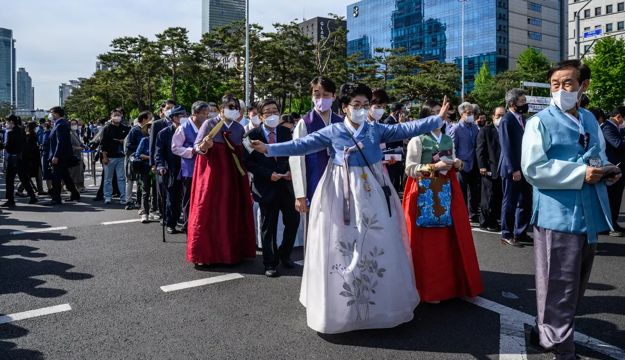 <p>Sejumlah tamu undangan mengenakan pakaian tradisonal saat tiba menjelang pelantikan presiden baru Korea Selatan, Yoon Suk-yeol di Majelis Nasional di Seoul, Selasa (10/5/2022). Yoon Suk-yeol akan dilantik sebagai Presiden Korea Selatan untuk periode kepresidenan ke-20 pada hari Selasa ini. (ANTHONY WALLACE / AFP)</p>