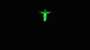 Pemandagan Patung Kristus Penebus menyala berwarna hijau di Rio de Janeiro, Brasil (19/4). Patung tersebut diberi cahaya hijau untuk menandai hari Tentara Nasional. (AFP Photo/Carl De Souza)