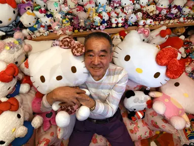 Seorang pensiunan perwira polisi Jepang yang bernama Masao Gunji berfoto bersama koleksi boneka Hello Kitty di rumahnya di Yotsukaido, Chiba, Jepang (28/6). (AFP Photo/AFPBB/Yoko Akiyoshi)