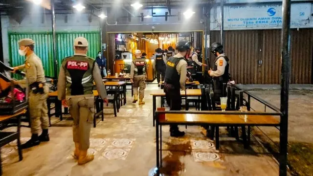 Personel Polresta Pekanbaru bersama Satpol PP membubarkan pengunjung cafe.