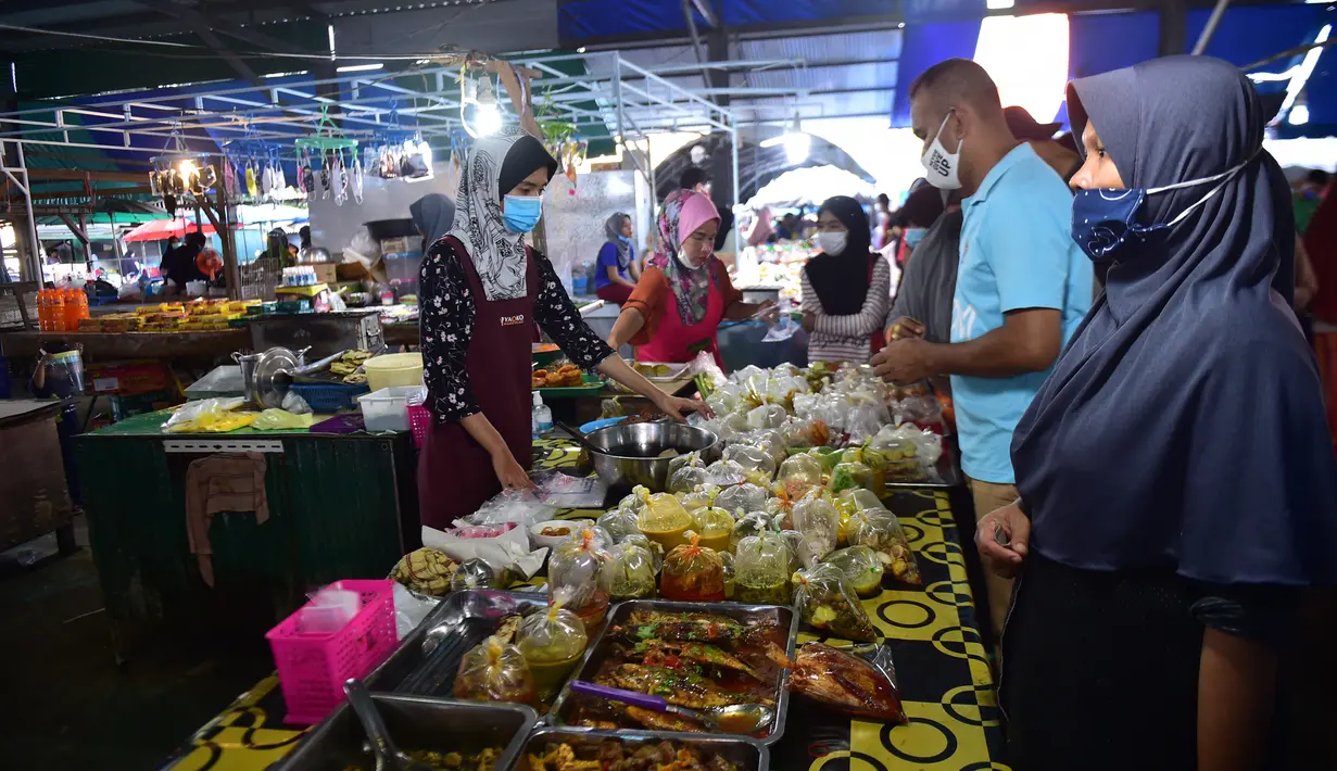 Orang-orang berbelanja di pasar makanan pada hari pertama bulan suci Ramadhan di provinsi Narathiwat di Thailand selatan (24/4/2020). Sejumlah pedagang menjual berbagai makanan selama bulan suci Ramadan di pasar tersebut. (AFP/Madaree Tohlala)