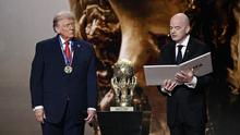 (Kiri/Kanan) Presiden AS, Donald Trump, memperhatikan saat menerima Hadiah Perdamaian FIFA (FIFA Peace Award) dari Presiden FIFA, Gianni Infantino, selama pengundian Piala Dunia 2026 yang berlangsung di AS, Kanada, dan Meksiko, di Kennedy Center, Washington, DC, pada 5 Desember 2025. (Brendan SMIALOWSKI/AFP)
