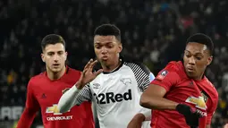 Pemain Manchester United Anthony Martial (kanan) berebut bola dengan pemain Derby County Morgan Whittaker pada pertandingan putaran kelima Piala FA di Pride Park, Derby, Inggris, Kamis (5/3/2020). Manchester United menang dengan skor 3-0. (AP Photo/Rui Vieira)