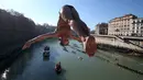 Seorang pria Italia bernama, Marco Fois melompat ke Sungai Tiber dari jembatan Cavour, Roma, Italia (1/1). Tradisi ini dimulai kembali pada tahun 1946 hingga sekarang. (Reuters/Alessandro Bianchi)