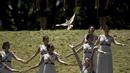 Para aktris menari dan melepaskan burung merpati saat upacara penyalaan api olimpiade di Candi Hera yang terletak di bekas kota tua Olympia, Yunani, Kamis (21/4/2016). (AFP/Aris Messinis)