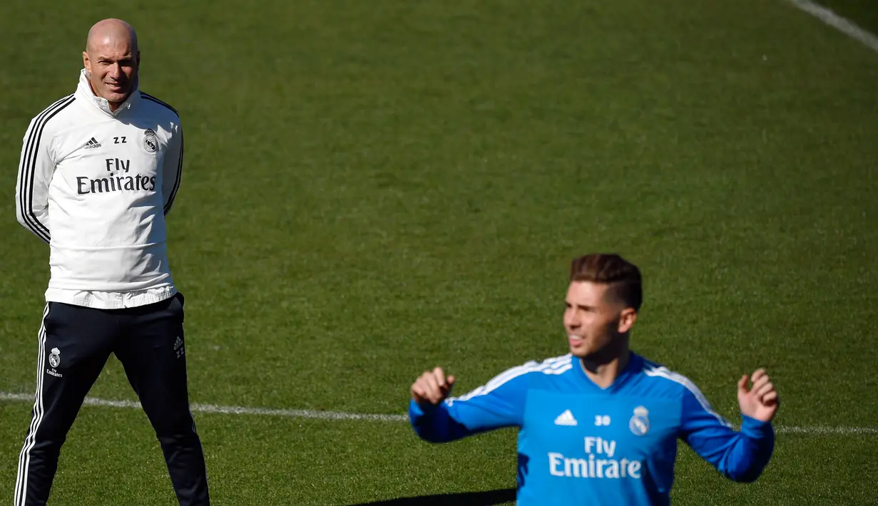 Pelatih Real Madrid Zinedine Zidane melihat kiper Luca Zidane berlatih di fasilitas pelatihan Valdebebas di Madrid (15/3). Zidane kembali melatih Real Madrid menggantikan Santiago Solari. (AFP Photo/Gabriel Bouys)