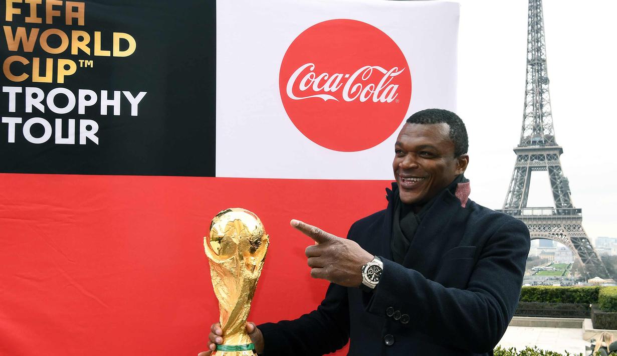 Mantan bek Prancis, Marcel Desailly berpose dengan trofi Piala Dunia dengan latar menara Eiffel selama FIFA World Cup Trophy Tour di Paris (20/3). Piala Dunia 2018 diselenggarakan 14 Juni dan 15 Juli 2018 di Rusia. (AFP Photo/Franck Fife)