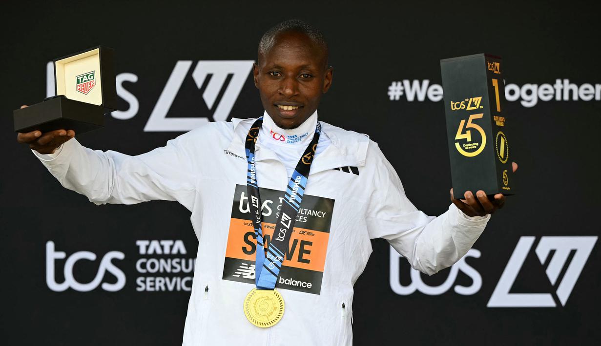 Pelari Kenya, Sabastian Sawe mengangkat trofi setelah memenangkan ajang London Marathon 2025 di London, Inggris, Sabtu (27/04/2025) waktu setempat. (AFP/Justin Tallis)