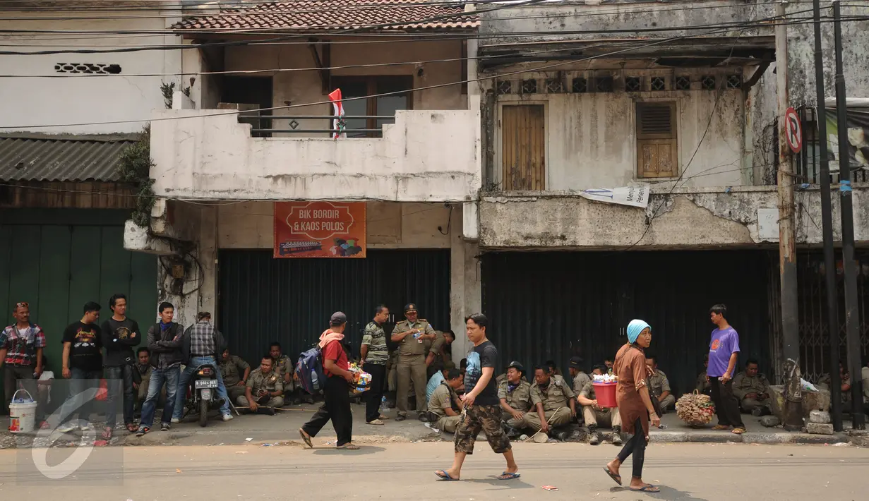 Warga melintas di depan toko yang ada di Jalan Jatinegara Barat,  Jakarta, Jumat (21/8/2015). Penutupan terkait proses penggusuran warga yang tinggal di sekitar bantaran Kali Ciliwung di Kampung Pulo Jakarta Timur. (Liputan6.com/Helmi Fithriansyah)