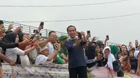 Presiden Joko Widodo berswafoto bersama saat pembentangan Kain Jumputan Palembang terpanjang di atas Jembatan Ampera (Liputan6.com / Nefri Inge)