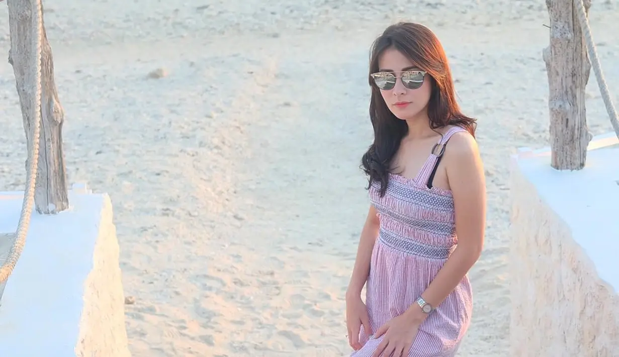 Aura kecantikan Rina Diana memang begitu terpancarkan ketika sedang melepas penat di pantai. Gaya santainya ini semakin menawan dengan memakai kacamata yang menutupi matanya. Dengan gaya seperti ini, Rina banjir pujian netizen.(Liputan6.com/IG/@rinadiana_8)