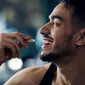 Seorang pria mengonsumsi suplemen kesehatan. (Shutterstock/Prostock-studio)