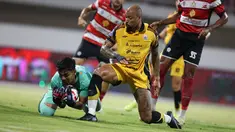 Pemain Persija Jakarta, Gustavo Almeida (kanan) berduel dengan kiper Madura United pada lanjutan BRI Super League 2025/2026 di Stadion Gelora Ratu Pamelingan, Jumat (24/10/2025) malam WIB. (Bola.com/Abdul Aziz).