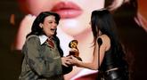 Penyanyi sekaligus penulis lagu asal Inggris, Lola Young (kiri) menerima penghargaan untuk kategori Penyanyi Pop Terbaik dari Charli XCX di atas panggung Penghargaan GRAMMY ke-68 di Crypto.com Arena, Los Angeles, California, pada 1 Februari 2026. (KEVIN WINTER/GETTY IMAGES NORTH AMERICA/Getty Images via AFP)