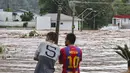 Orang-orang mengamati jalan yang banjir setelah hujan lebat di Encantado, Rio Grande do Sul, Brasil, Rabu (1/5/2024). (Photo by Gustavo Ghisleni / AFP)