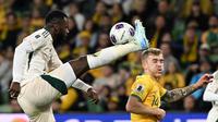 Pemain Arab Saudi Hassan Al-Tambakti (kiri) membuang bola saat menghadapi Australia pada kualifikasi Piala Dunia 2026 zona Asia di Melbourne, Kamis (14/11/2024). (AFP/William West)