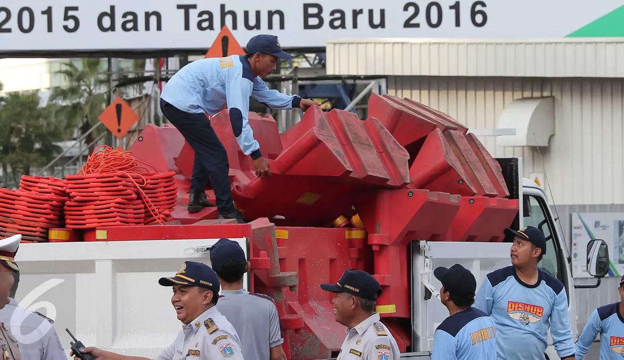 Petugas Dinas Perhubungan menata pembatas jalan untuk menutup sejumlah titik yang menuju kawasan Bundaran HI, Jakarta, Kamis (31/12). Hal ini dilakukan agar perayaan tahun baru tak terpusat di Bundaran Hotel Indonesia. (Liputan6.com/Angga Yuniar)