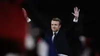Presiden terpilih Emmanuel Macron melambaikan tangannya kepada para pendukung saat pidato kemenangan di Museum Louvre Paris pada 7 Mei 2917 (Patrick KOVARIK / AFP)