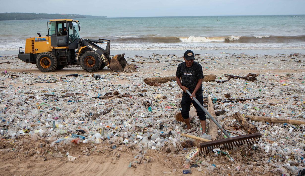 Sebagai komitmen menjaga citra pariwisata Bali, ribuan relawan, termasuk TNI-Polri bersama-sama melakukan aksi bersih pantai (korve) serentak di Pantai Jimbaran sejak 5 Maret 2026. Tampak dalam foto, para pekerja dan warga membersihkan ceceran dan tumpukan sampah plastik yang terdampar di Pantai Jimbaran, Bali, pada Selasa 10 Maret 2026. (Lana Priatna/AFP)