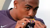 Pesepakbola muda Brasil, Malcom Filipe Silva de Oliveira mencium jersey berlogo Barcelona setibanya di stadion Camp Nou, Selasa (24/7). Winger berusia 21 tahun itu siap memberikan kegembiraan kepada publik Camp Nou. (AP Photo/Manu Fernandez)