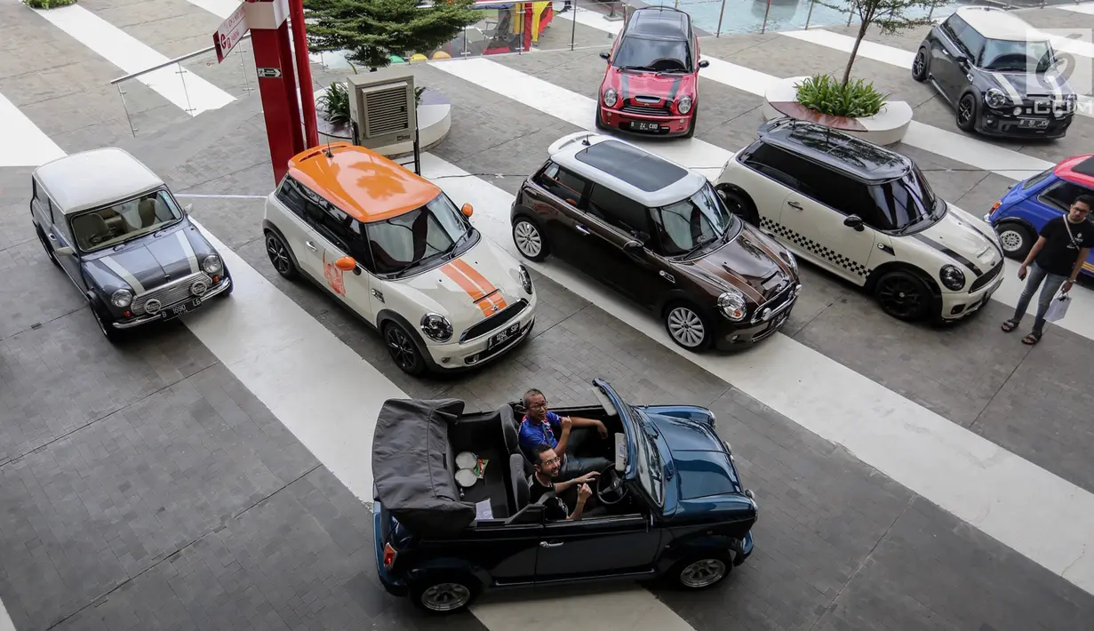 Presiden Director BMW Group, Ramesh Divyanatha dan Co Founder Indonesia Coopret Registry, Peter Anugrah menaiki mobil mini klasik pada Indonesia Mini Day 2018 di QBig BSD, Tangerang, Sabtu (15/12). (Liputan6.com/Fery Pradolo)